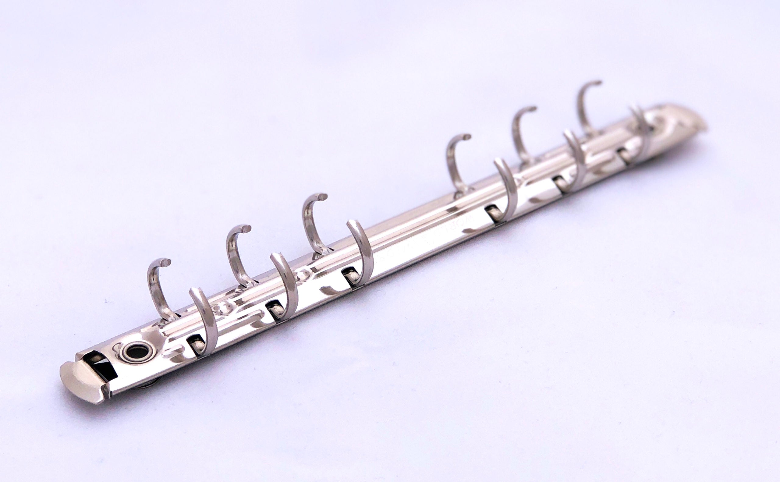 Mecanismo de media pulgada con seis argollas y palancas laterales, acabado níquel, ideal para carpetas, agendas y organizadores. Incluye remaches como obsequio.