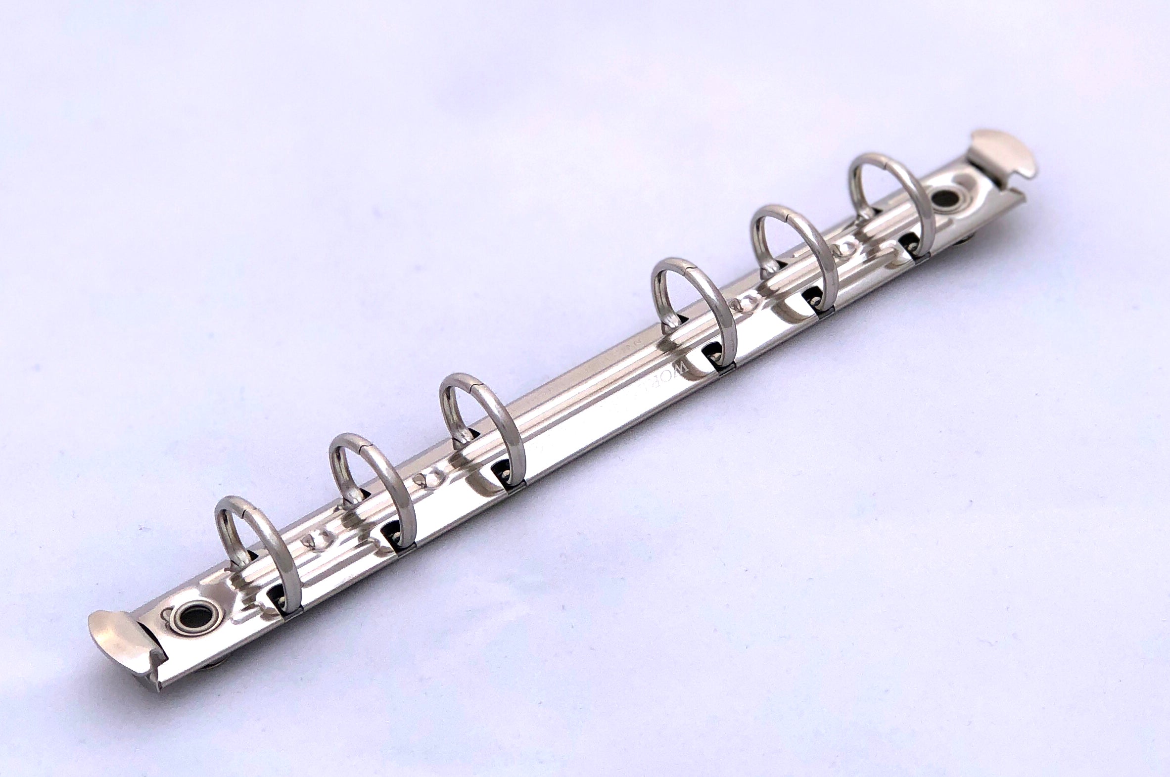 Mecanismo de media pulgada con seis argollas y palancas laterales, acabado níquel, ideal para carpetas, agendas y organizadores. Incluye remaches como obsequio.