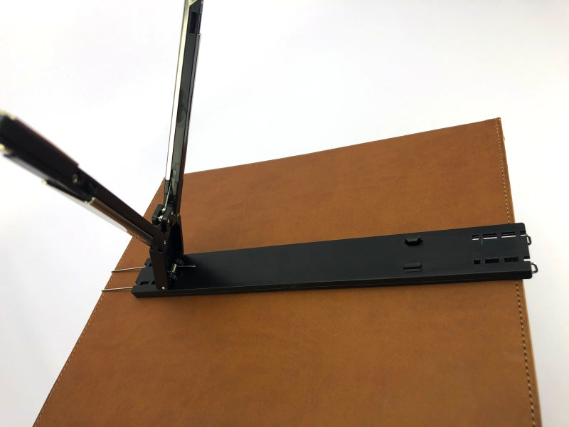 Atril de plástico color negro, diseño tipo trípode, ideal para carpetas, empaque mínimo de 100 piezas.