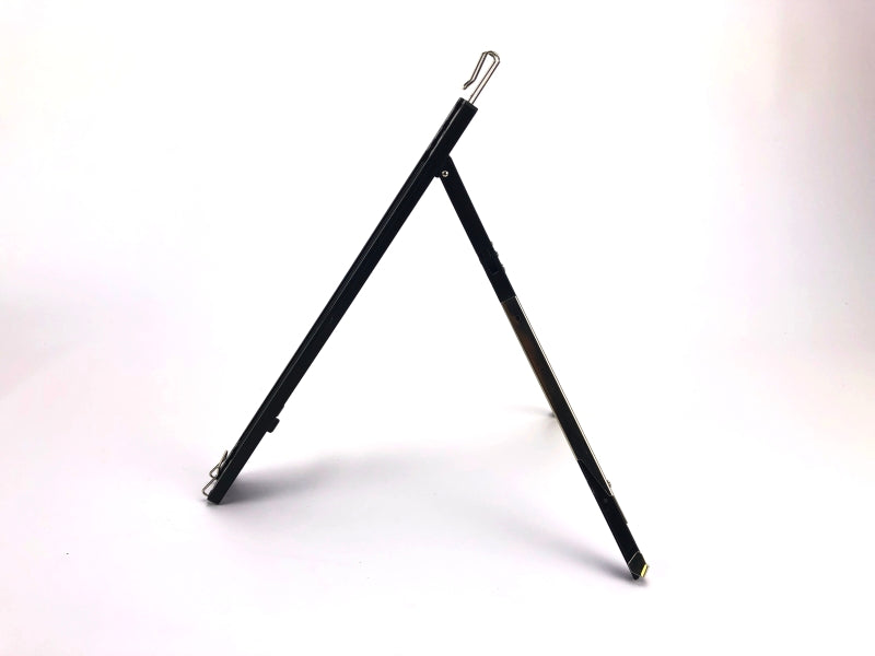 Atril de plástico color negro, diseño tipo trípode, ideal para carpetas, empaque mínimo de 100 piezas.