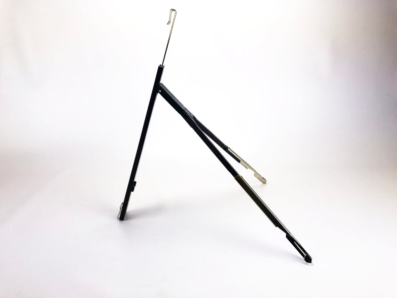 Atril de plástico color negro, diseño tipo trípode, ideal para carpetas, empaque mínimo de 100 piezas.