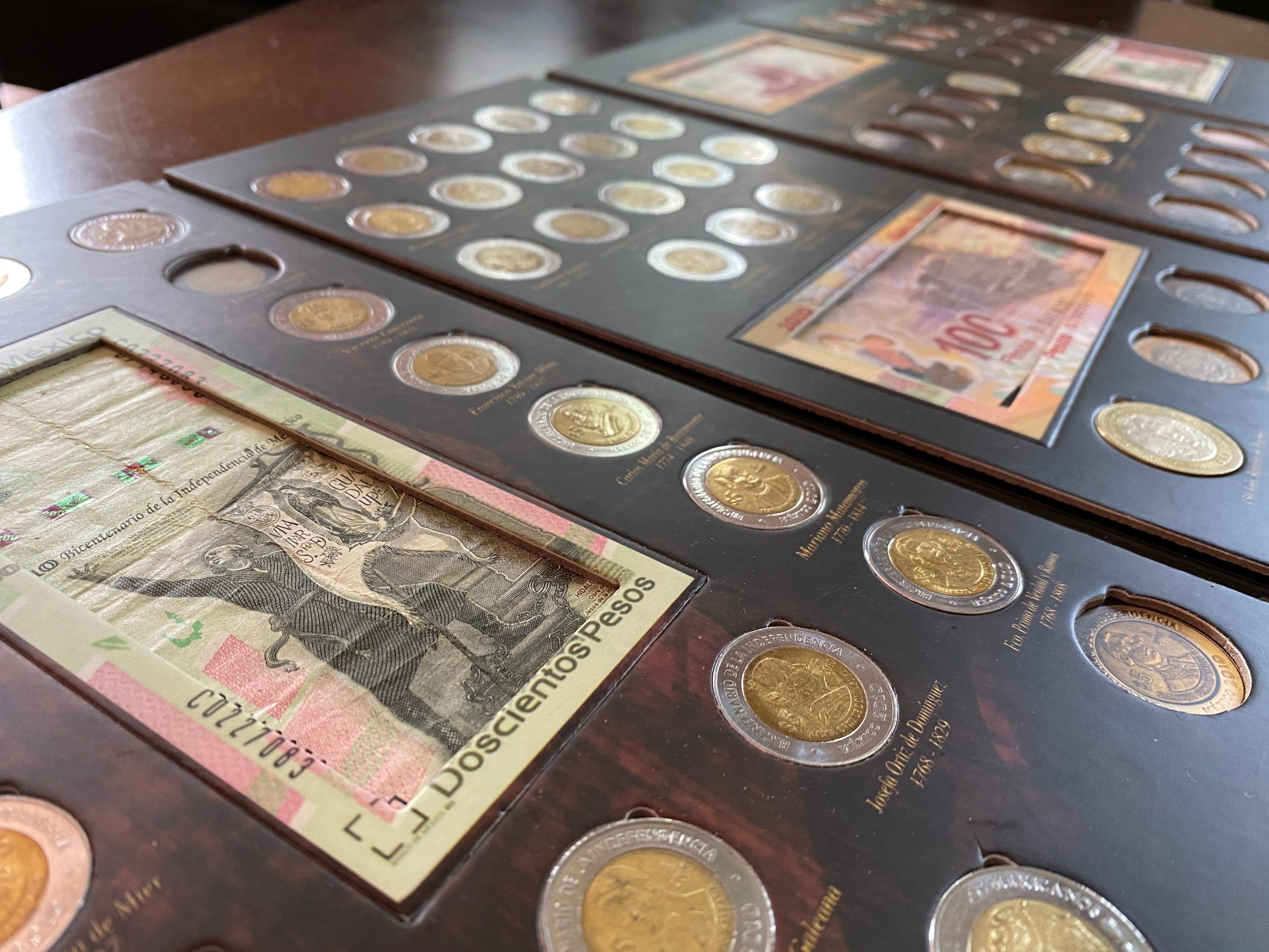 Álbum cuadríptico para monedas y billetes conmemorativos de México, incluye espacios para monedas de $5, $10 y $20 pesos, además de billetes de $20, $50, $100 y $200 pesos. Fabricado en cartón rígido con impresión offset y suaje preciso. Ideal para coleccionistas y numismáticos, incluye bolsa cerrada para protección